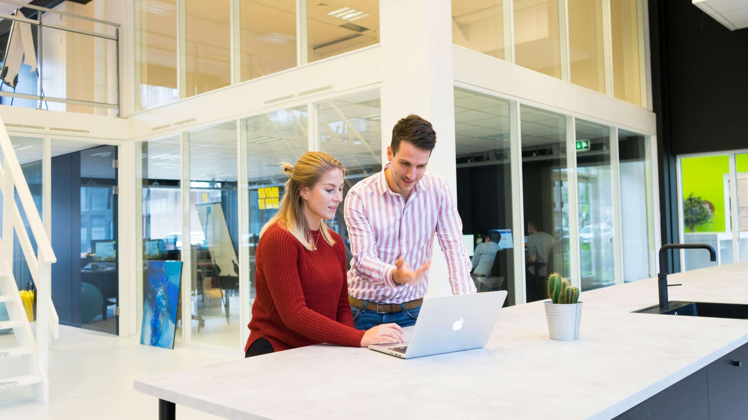 man and women using a laptop at a desk