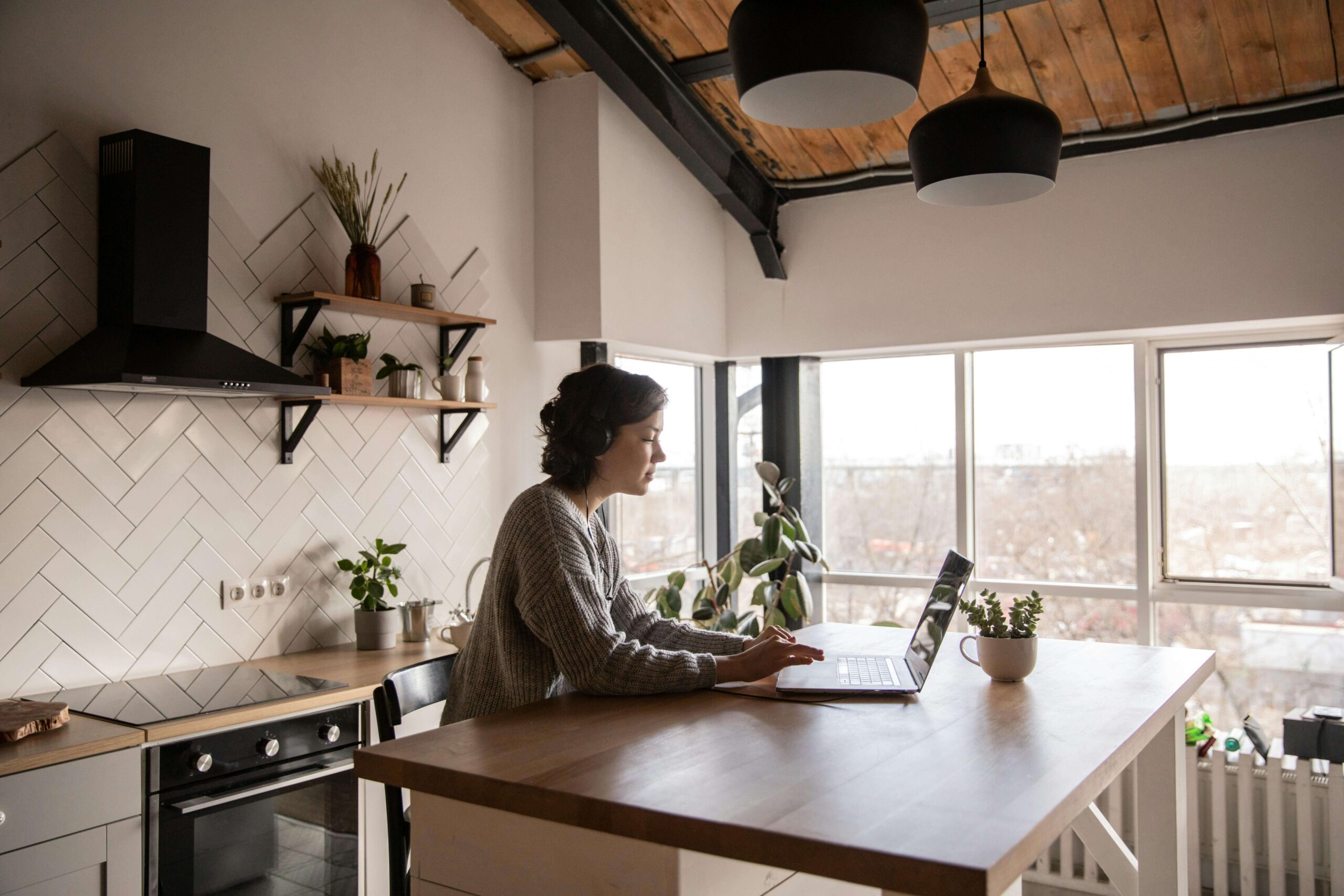person using a laptop at a kitchen table