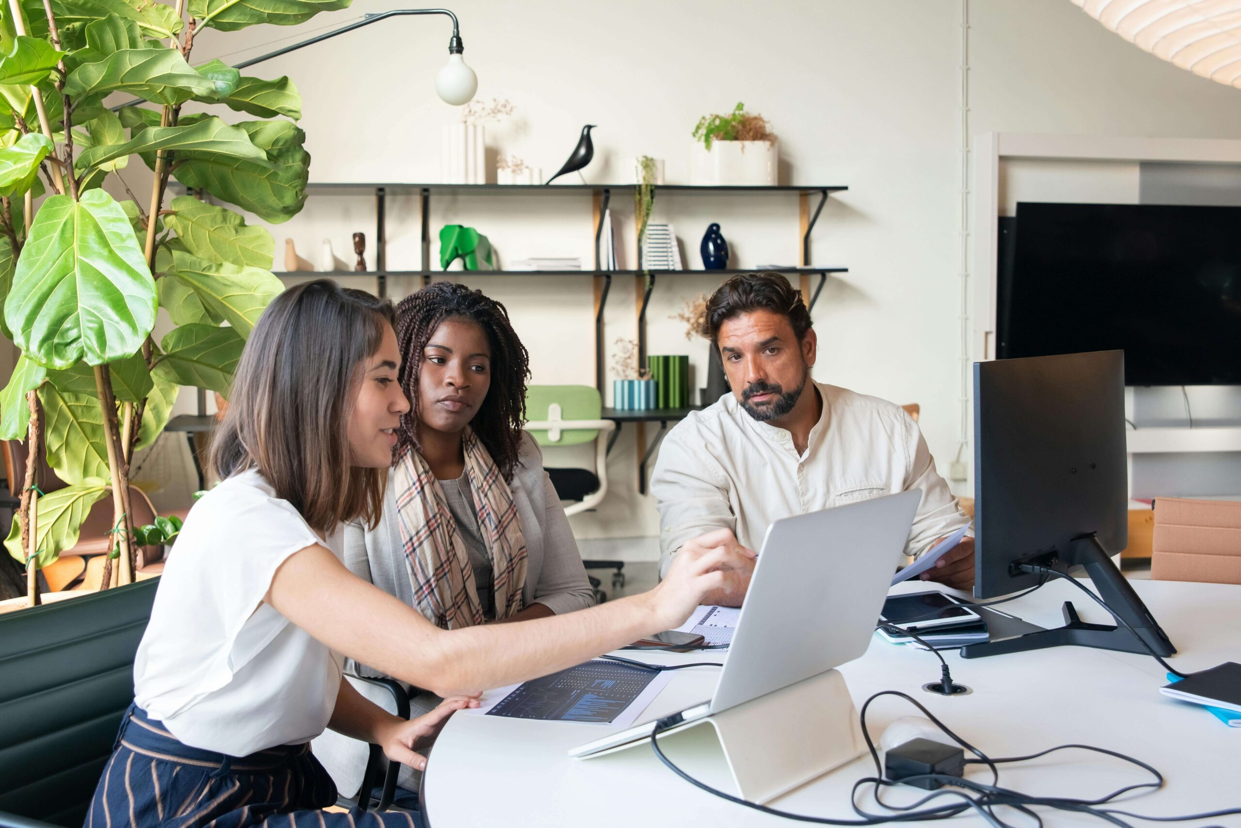 person showing two others a laptop